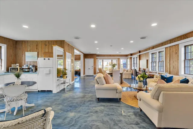 a living room with fireplace furniture and a large window