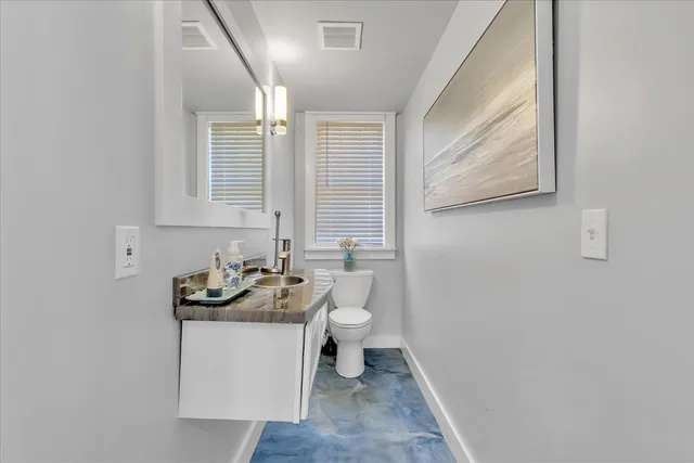 a bathroom with a sink toilet and window