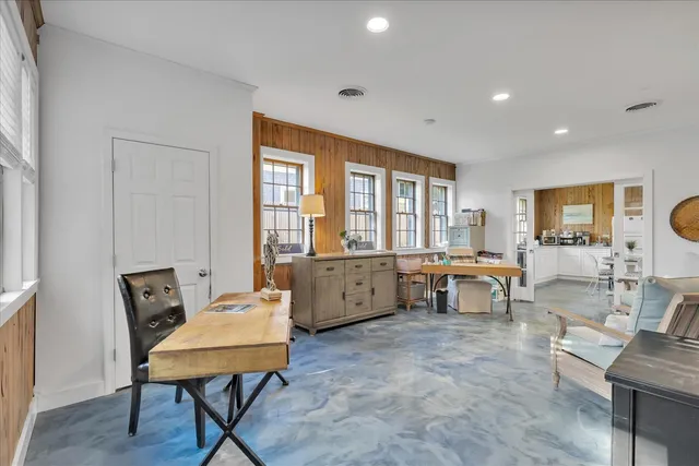 a living room with furniture and a dining table with wooden floor