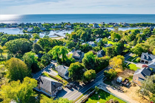 an aerial view of a house with a yard green space and lake view