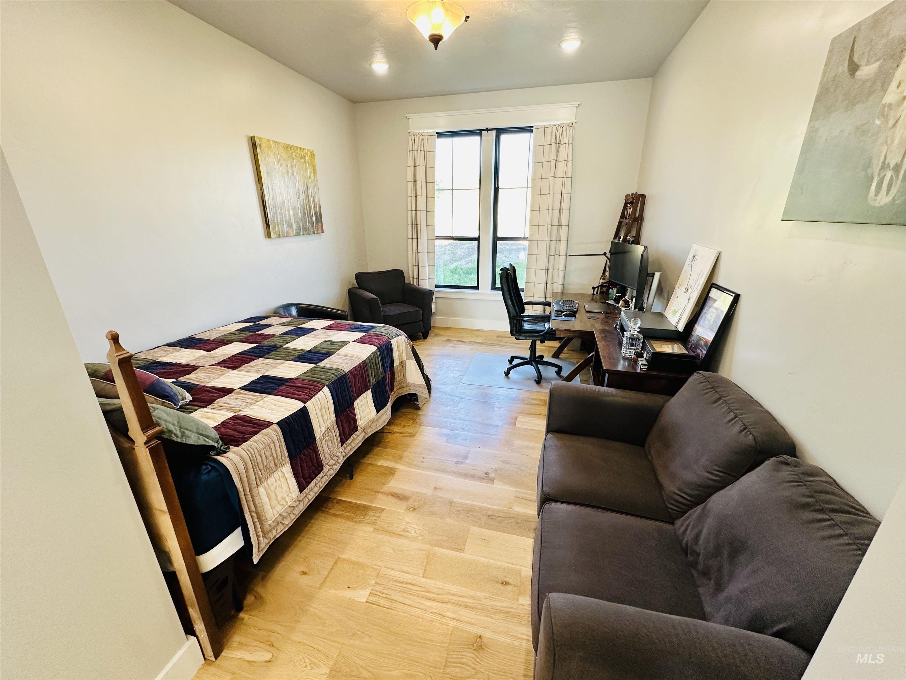 876 Coyote Gulch Road Adrian, OR 97901 - Photo 23 of 50 Interior room featuring wood-finish flooring, a large window with dark trim, recessed lighting, and a decorative ceiling fixture