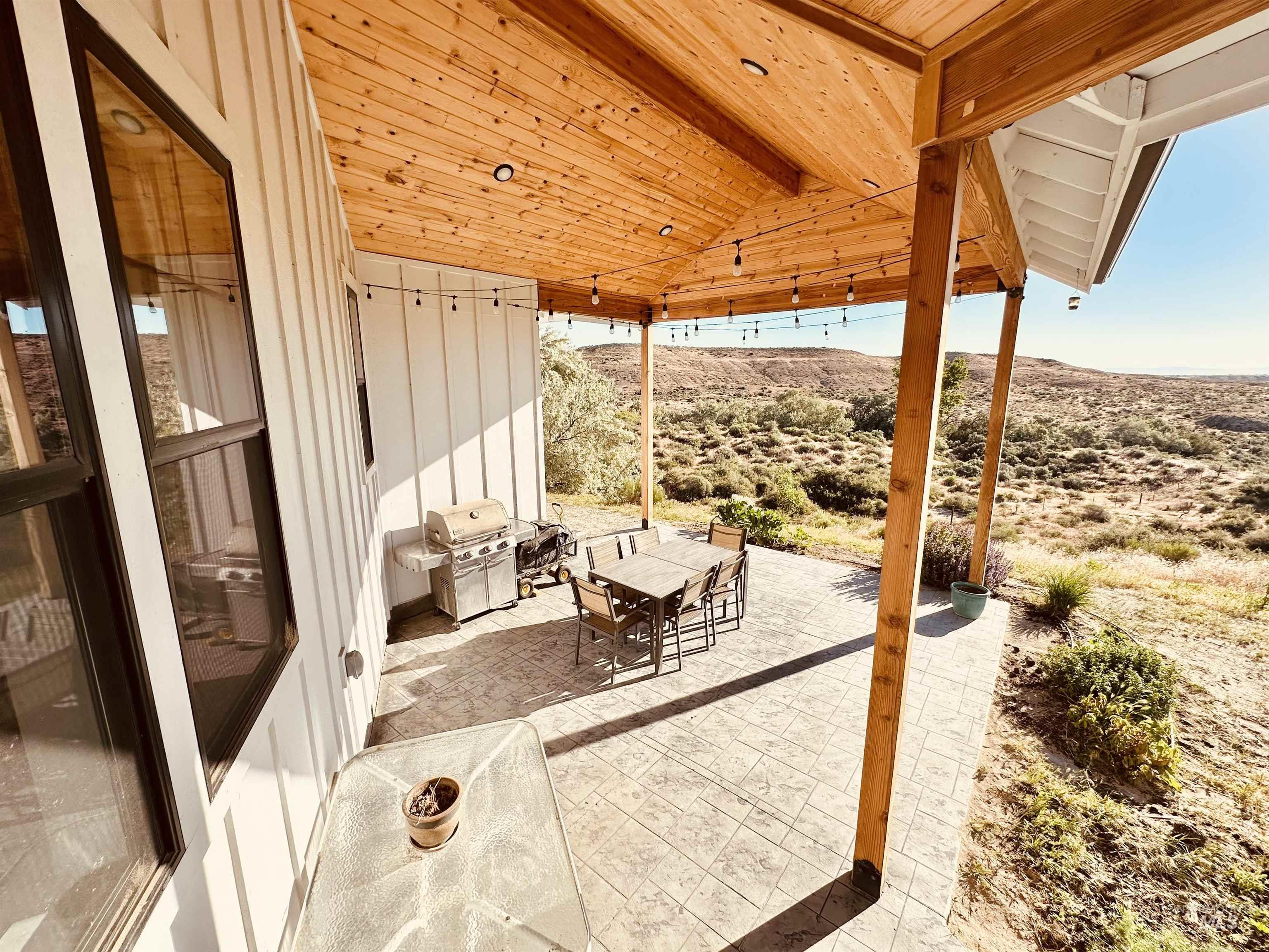 876 Coyote Gulch Road Adrian, OR 97901 - Photo 40 of 50 Covered outdoor patio featuring a wood-plank ceiling, exposed wood beams, and a stamped concrete surface