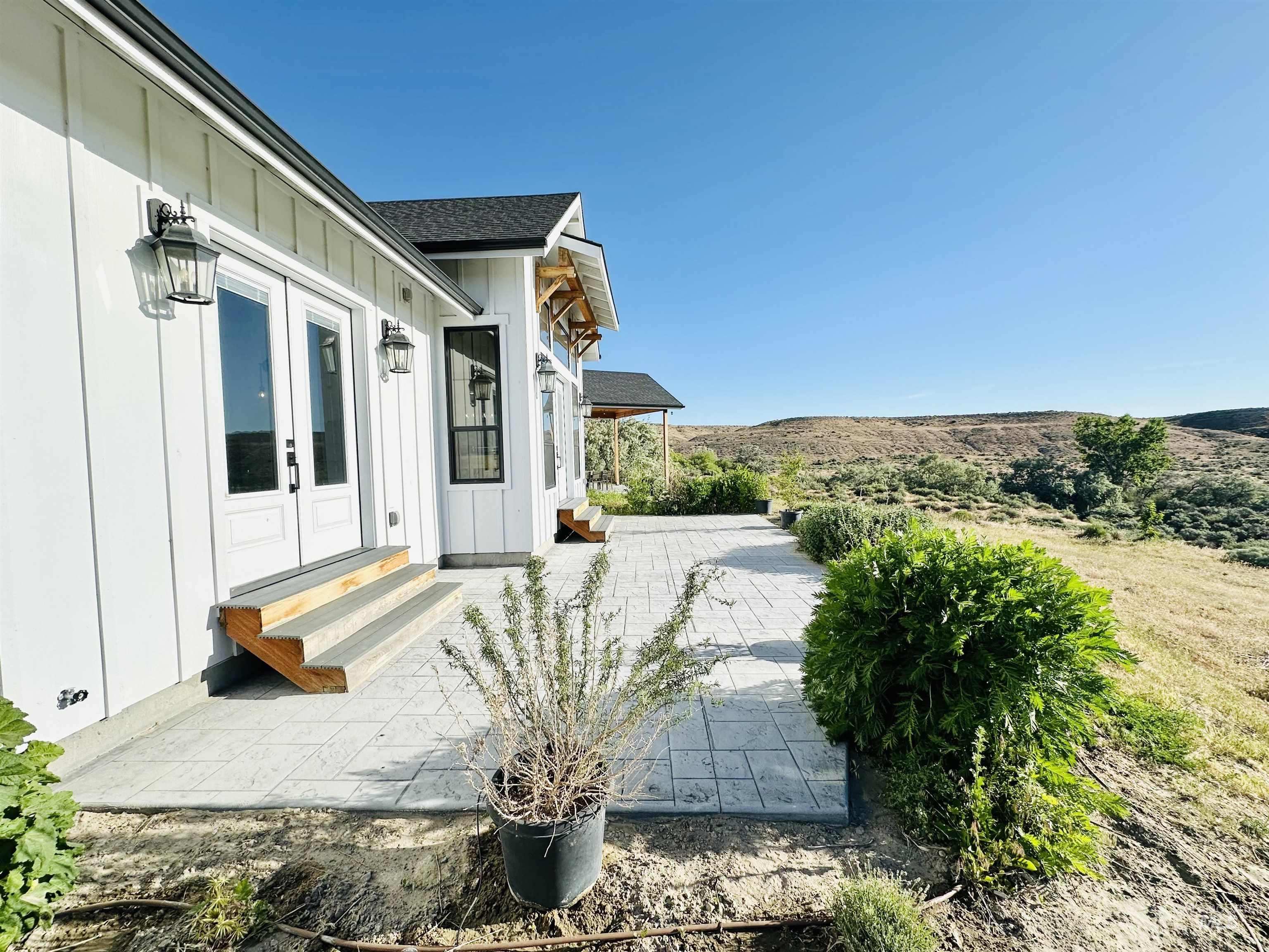 876 Coyote Gulch Road Adrian, OR 97901 - Photo 42 of 50 Exterior featuring board and batten siding, black asphalt shingle roofing, and black framed windows