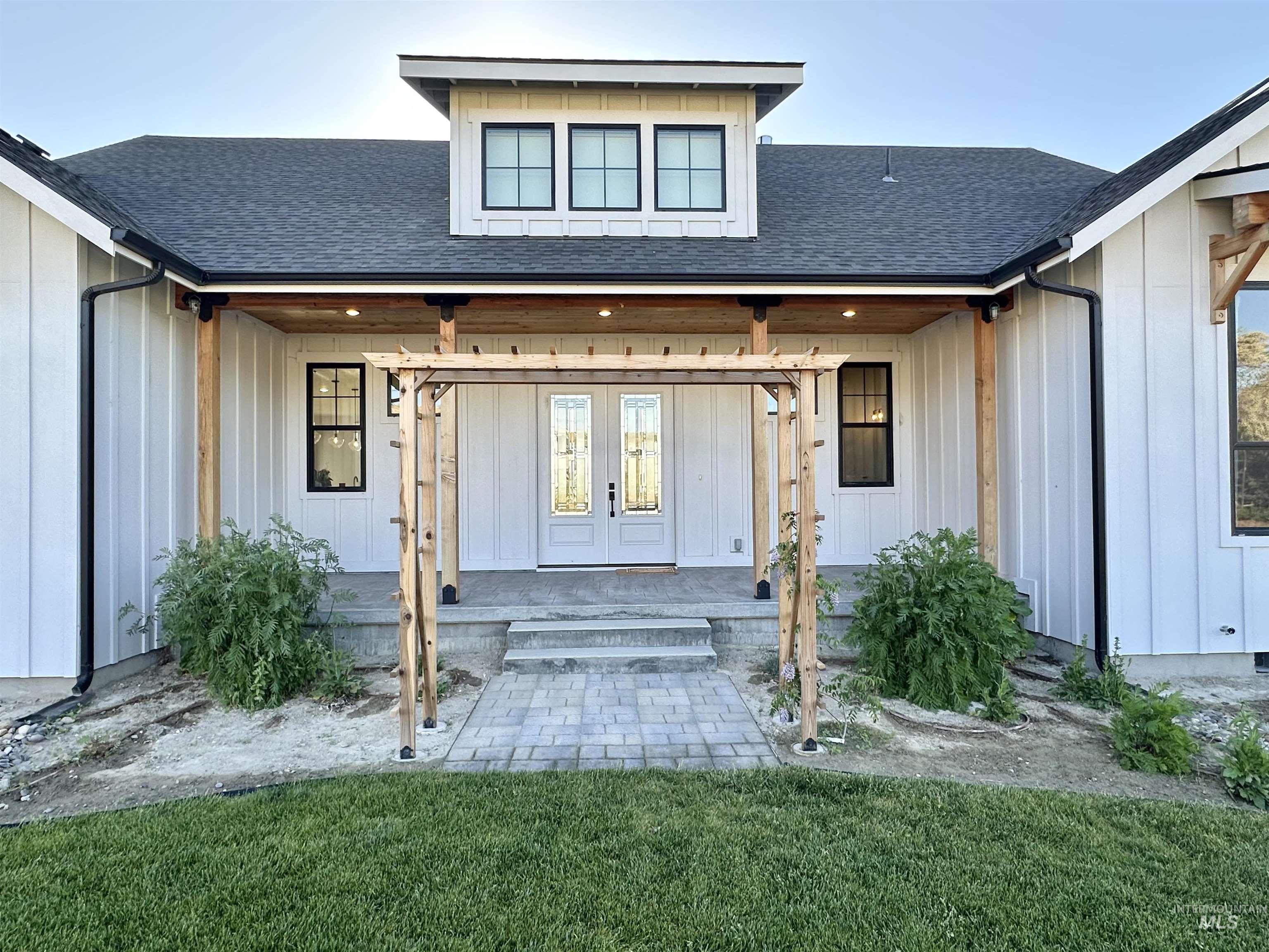 876 Coyote Gulch Road Adrian, OR 97901 - Photo 48 of 50 Modern farmhouse exterior featuring board and batten siding, black-framed windows, and a black shingled roof
