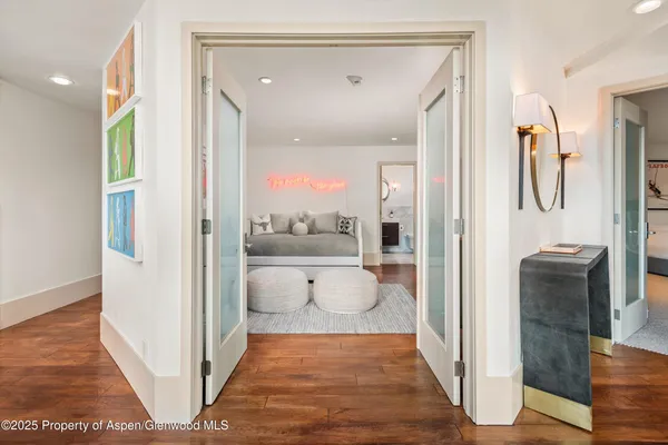 a view of a hallway with wooden floor and glass door