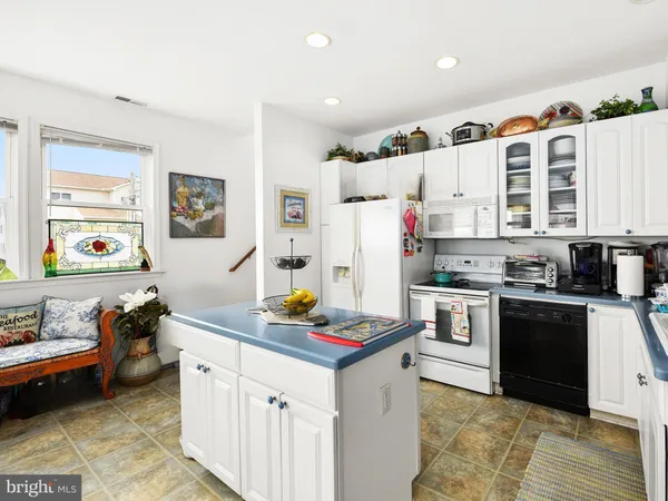a kitchen with stainless steel appliances kitchen island granite countertop a refrigerator and a stove top oven
