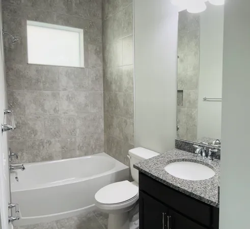 a bathroom with a granite countertop toilet a sink and a bathtub