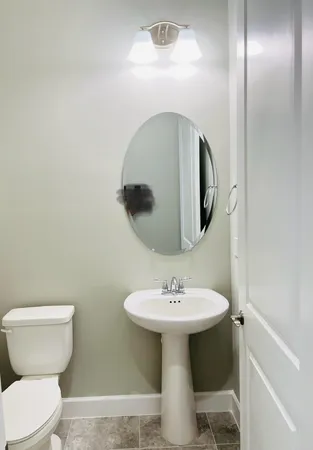 a bathroom with a toilet sink and mirror