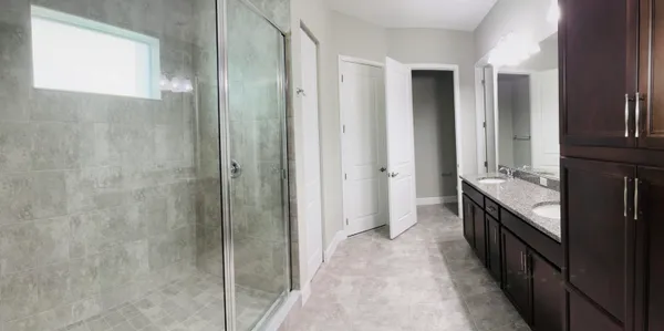 a bathroom with a double vanity sink a toilet and a shower