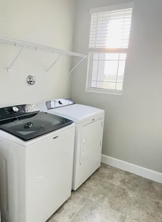 a sink with granite countertop cabinets and window