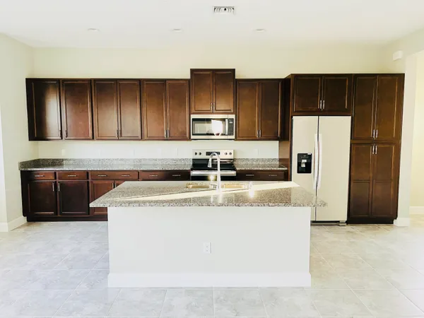 a view of a kitchen with a sink and refrigerator