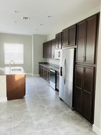 a kitchen with kitchen island a counter top space cabinets and stainless steel appliances