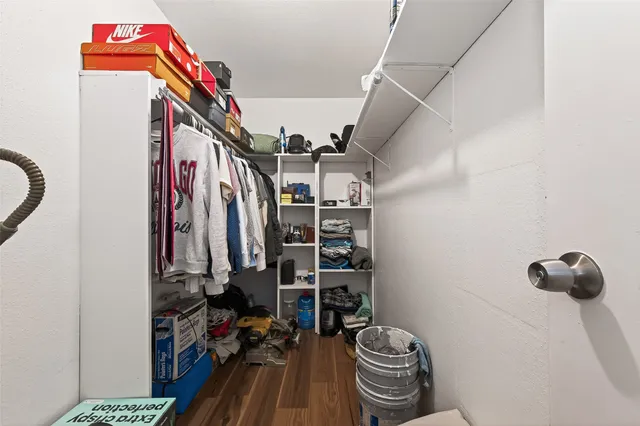 a view of walk in closet with clothes and shoes