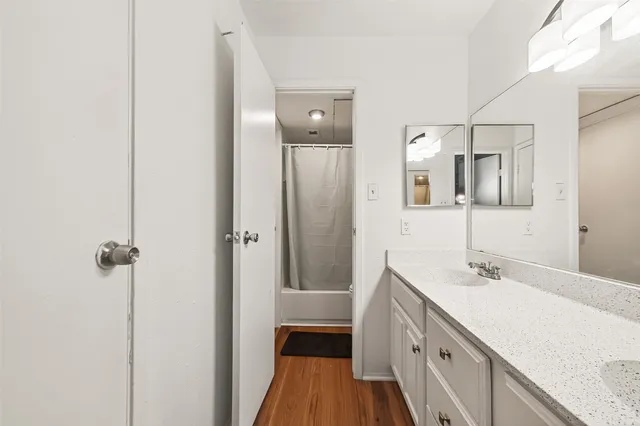 a bathroom with a double vanity sink a mirror and a shower