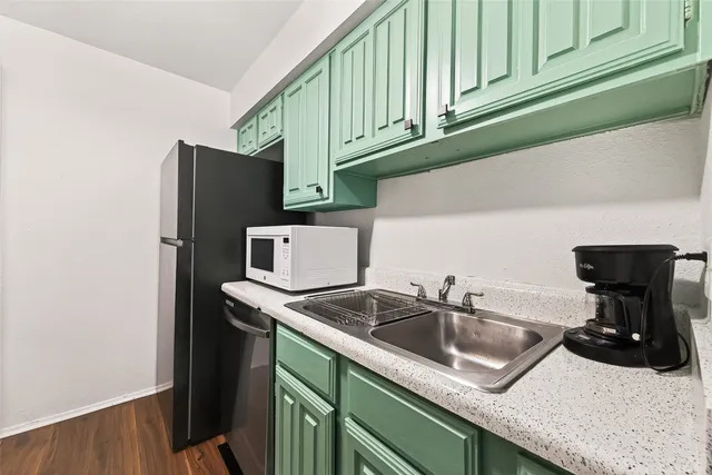 a kitchen with stainless steel appliances granite countertop a sink and a refrigerator