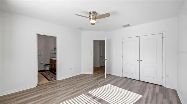 a view of a room with wooden floor and a ceiling fan