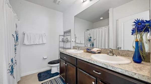 a bathroom with a granite countertop sink a mirror and a toilet