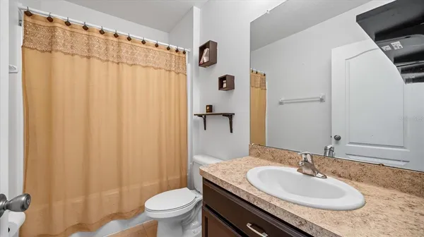 a bathroom with a granite countertop sink toilet and a mirror
