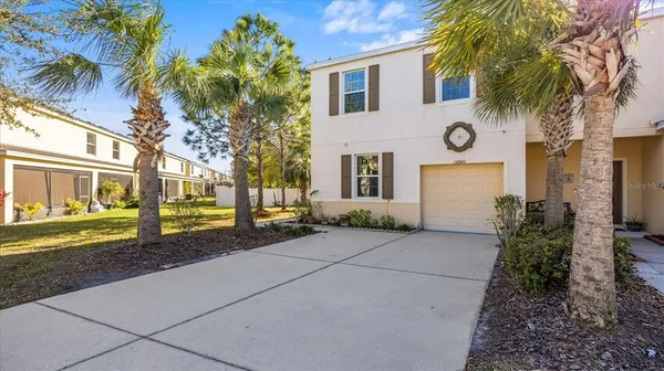 a view of a house with a small yard and palm trees