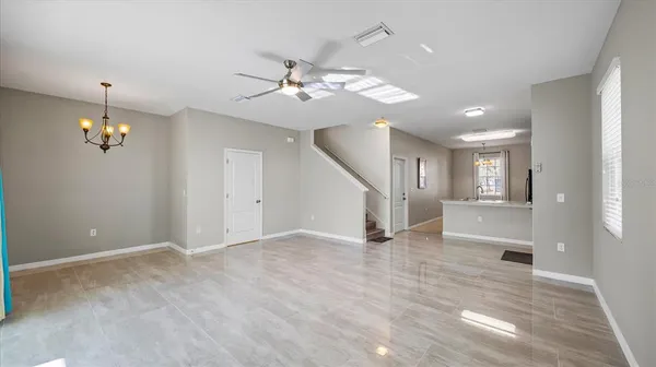 a view of an empty room with a window and a kitchen