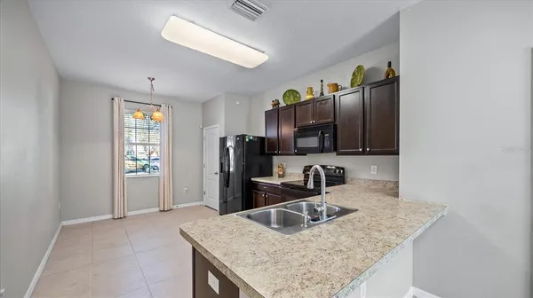 a kitchen with stainless steel appliances granite countertop a sink refrigerator and microwave
