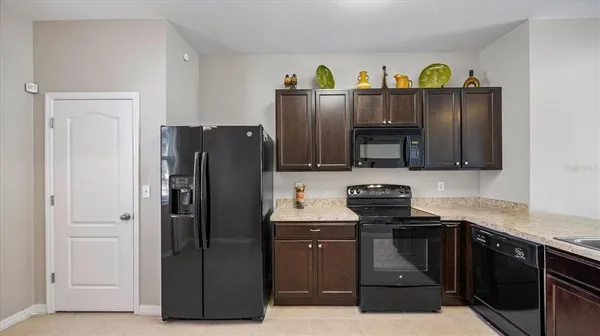 a kitchen with stainless steel appliances granite countertop a refrigerator and a stove top oven