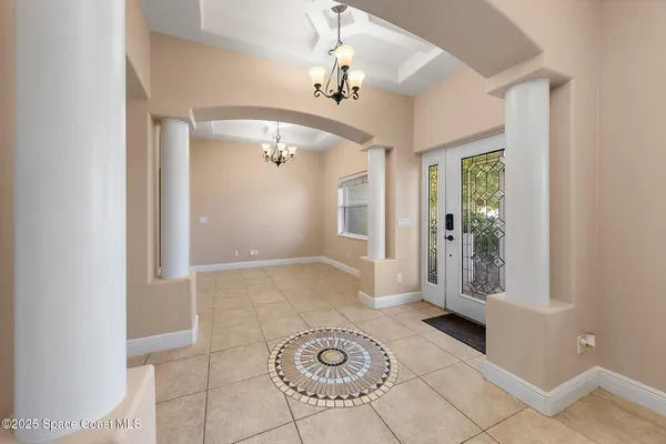 a view of a hallway with a chandelier fan and windows