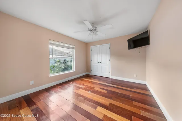 an empty room with a ceiling fan and a window