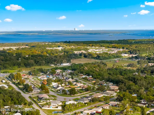 an aerial view of residential houses with outdoor space and swimming pool
