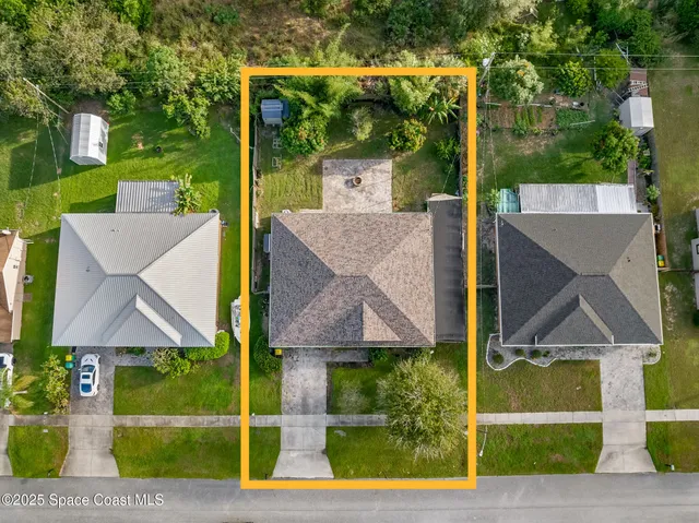 a view of a house with backyard and trees