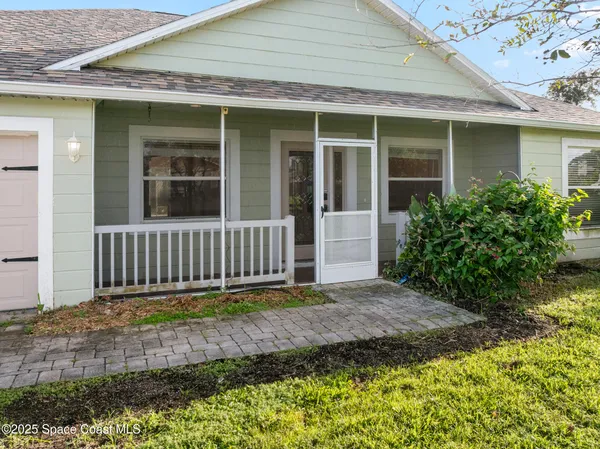 a view of a hallway with wooden floor and a living room