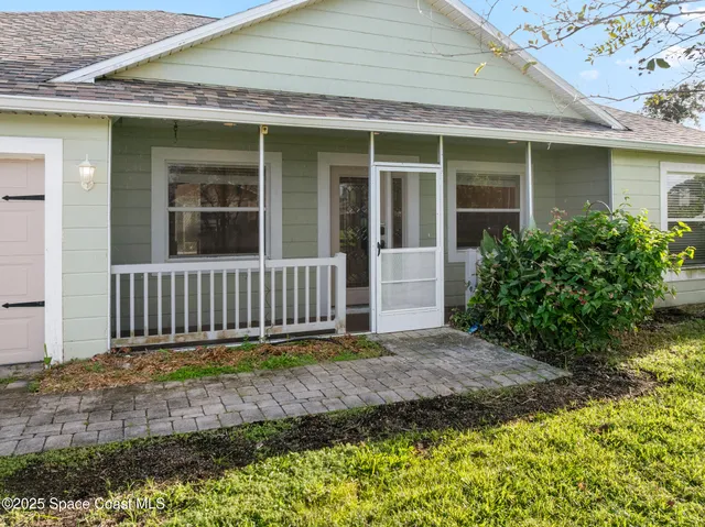 a view of a hallway with wooden floor and a living room