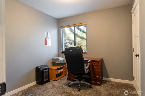 a view of a workspace with furniture and a window