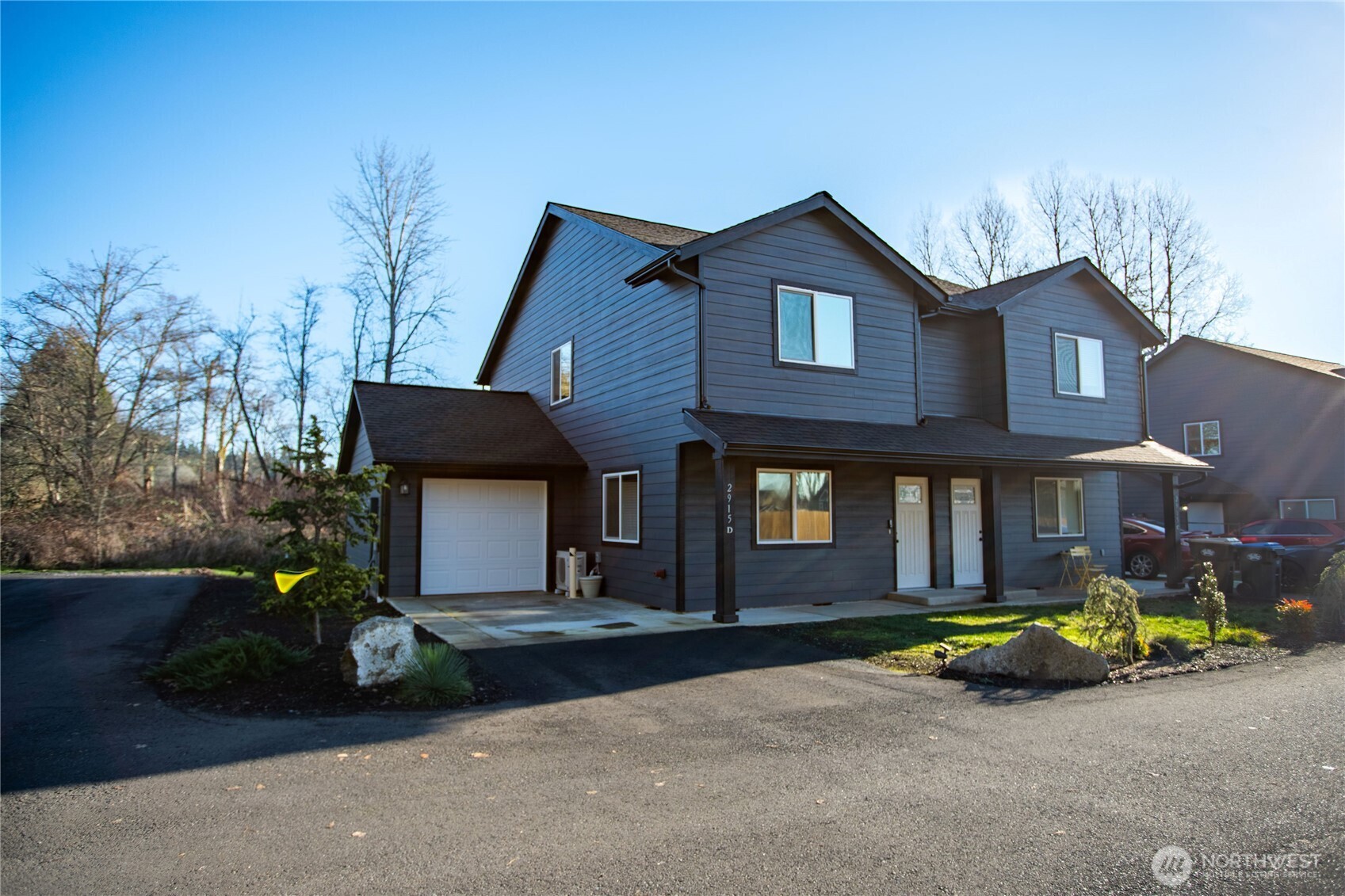 2915 Jackson Highway, Unit D Chehalis, WA 98532 - Photo 21 of 24 a view of a brick house with many windows and a yard