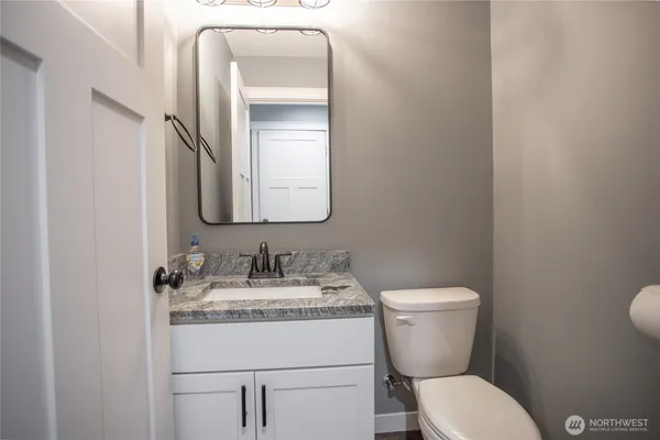 a bathroom with a toilet sink and mirror