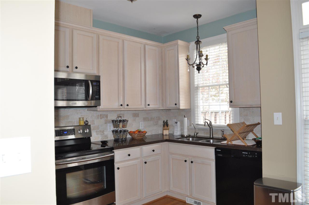 720 Parkham Lane Raleigh, NC 27603 - Photo 4 of 23 a kitchen with stainless steel appliances granite countertop white cabinets and a stove