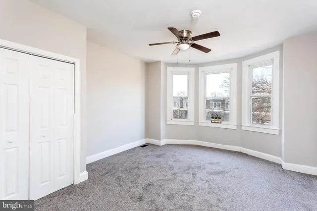 a view of a livingroom with a ceiling fan and window