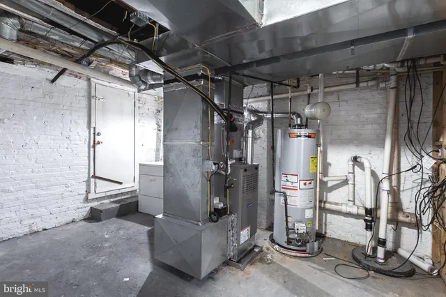 a view of a house with a barbeque and large trees
