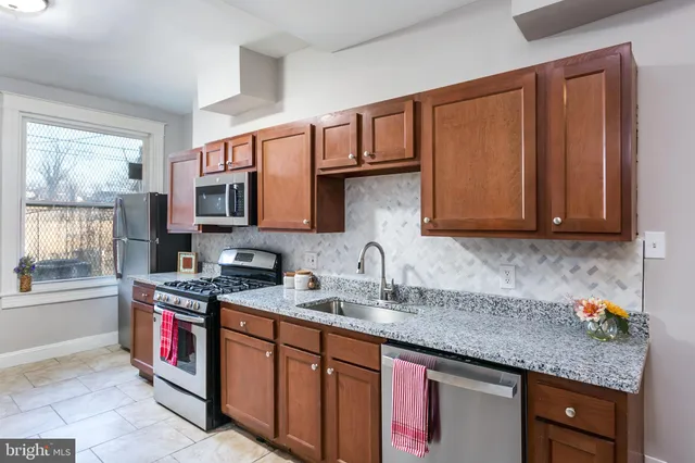 a kitchen with stainless steel appliances granite countertop a sink stove and cabinets