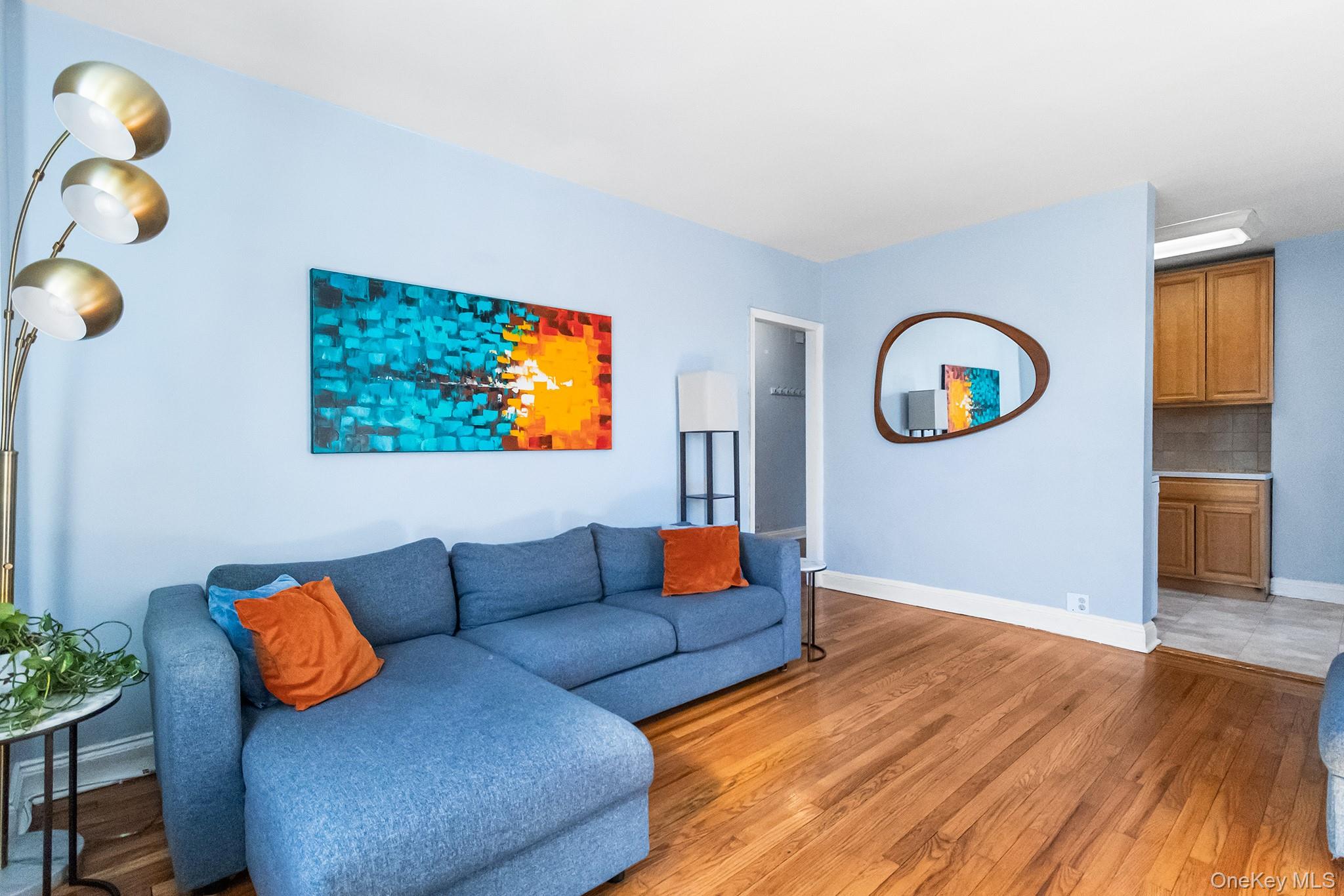 a living room with furniture and a painting on the wall