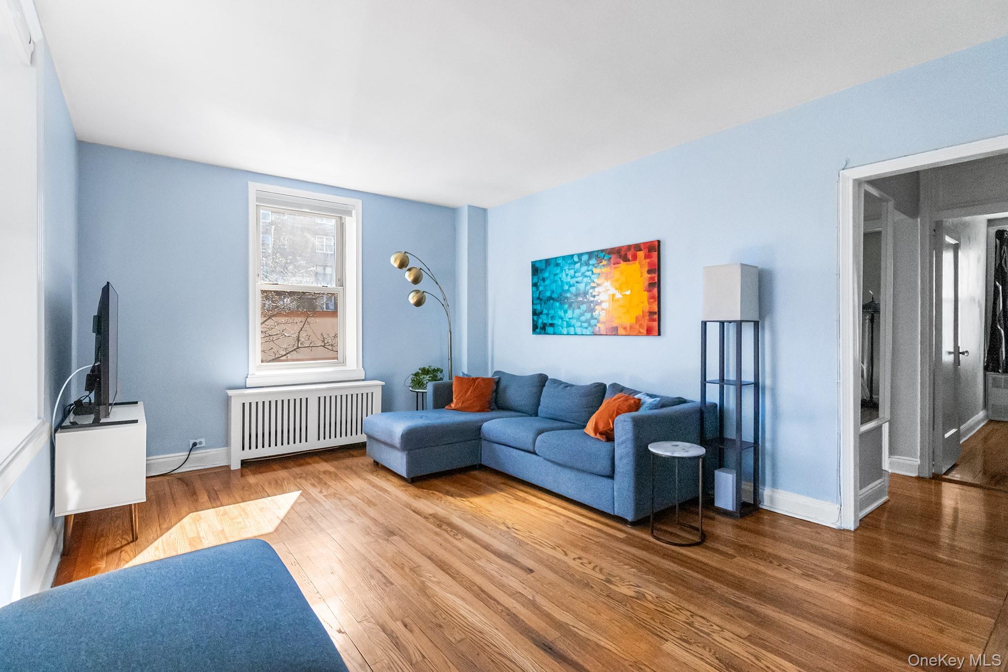 43-10 48th Avenue, Unit 2F Queens, NY 11377 - Photo 2 of 14 a living room with furniture and a flat screen tv