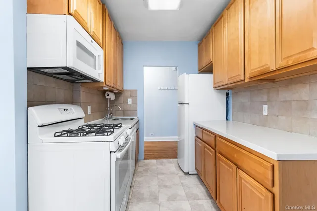 a kitchen with a stove top oven and refrigerator