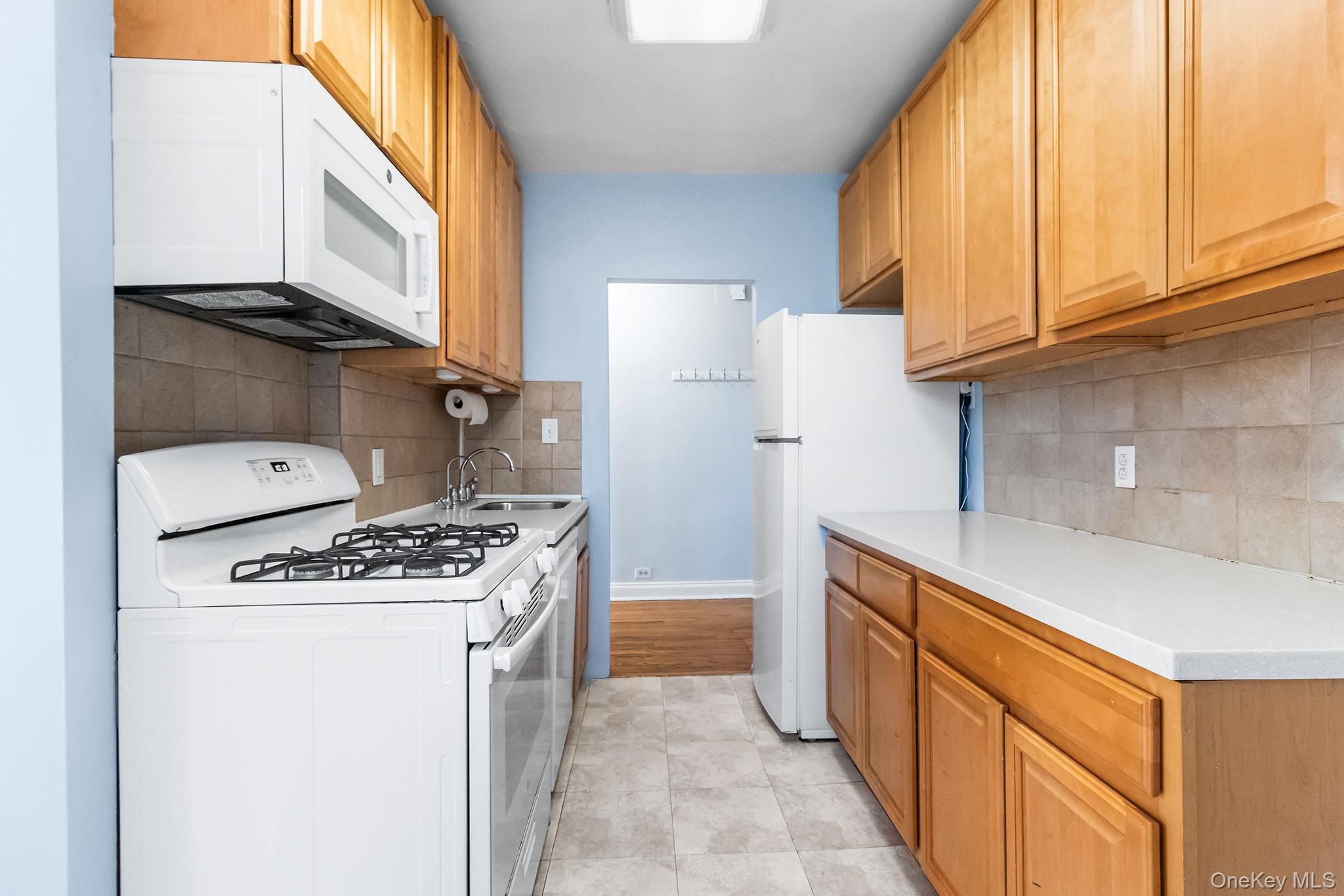 43-10 48th Avenue, Unit 2F Queens, NY 11377 - Photo 3 of 14 a kitchen with a stove top oven and refrigerator