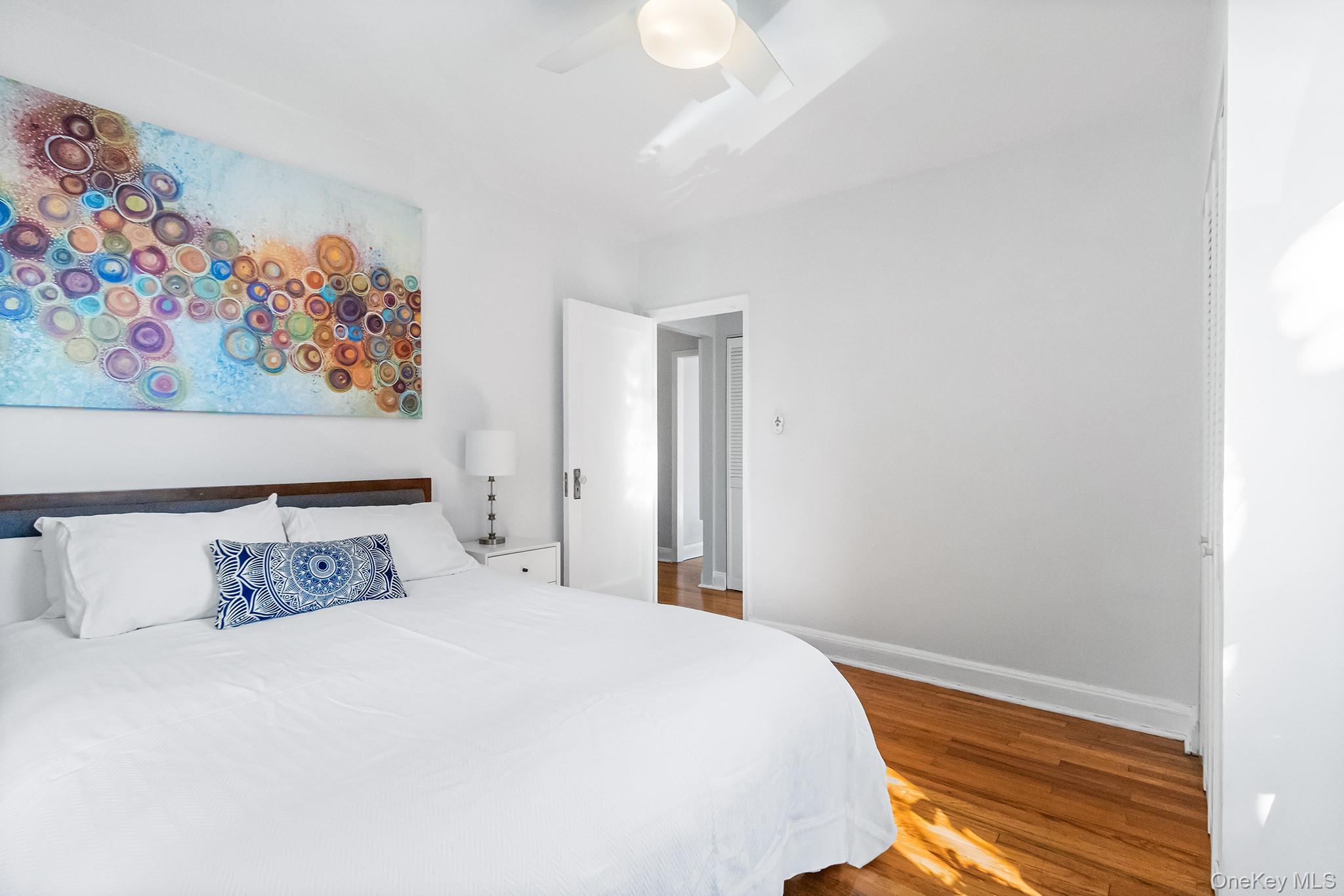 43-10 48th Avenue, Unit 2F Queens, NY 11377 - Photo 6 of 14 a bedroom with a bed and painting on the wall