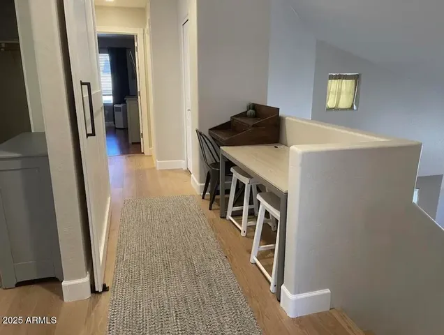 a view of a hallway with wooden floor and stairs