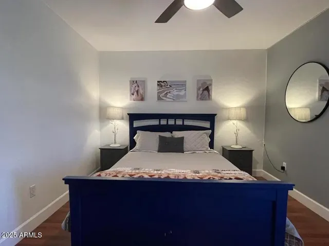 a bedroom with a bed and a lamp on dresser