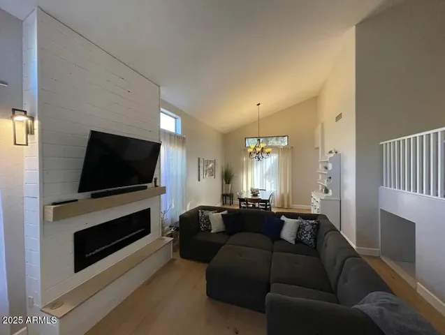 a living room with furniture a flat screen tv and a fireplace