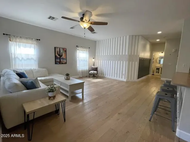 a living room with furniture and a wooden floor