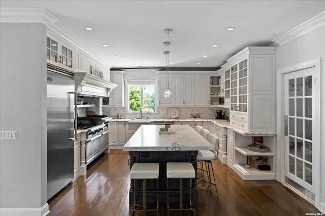 a kitchen with kitchen island a counter space a sink appliances and cabinets