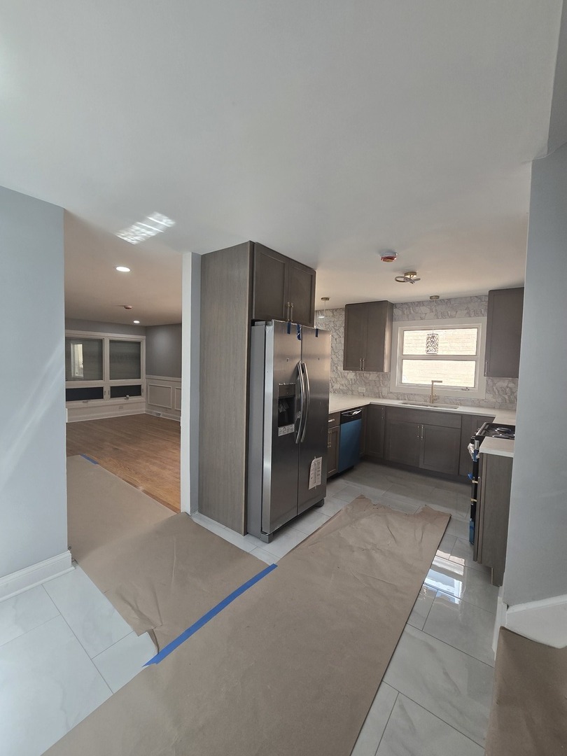 9727 South Michigan Avenue Chicago, IL 60628 - Photo 18 of 24 a kitchen with stainless steel appliances granite countertop a refrigerator and a sink